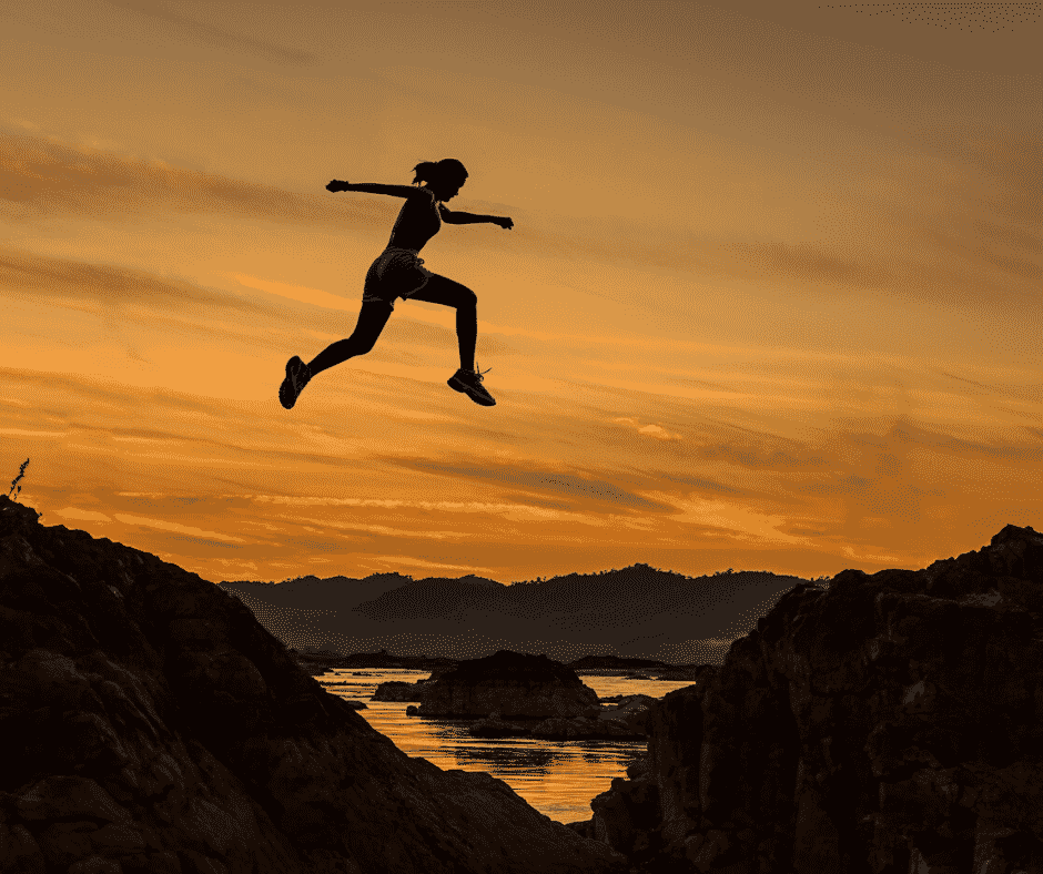 Woman leaping across a mountain