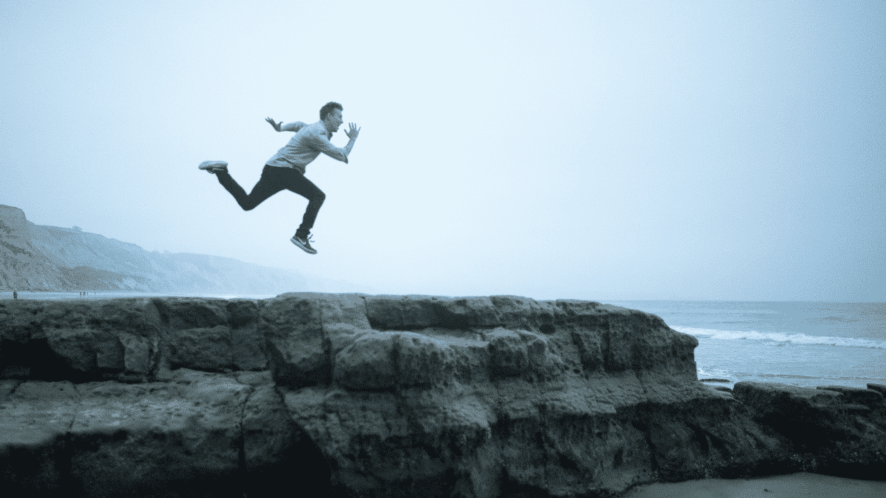 man jumping on cliff