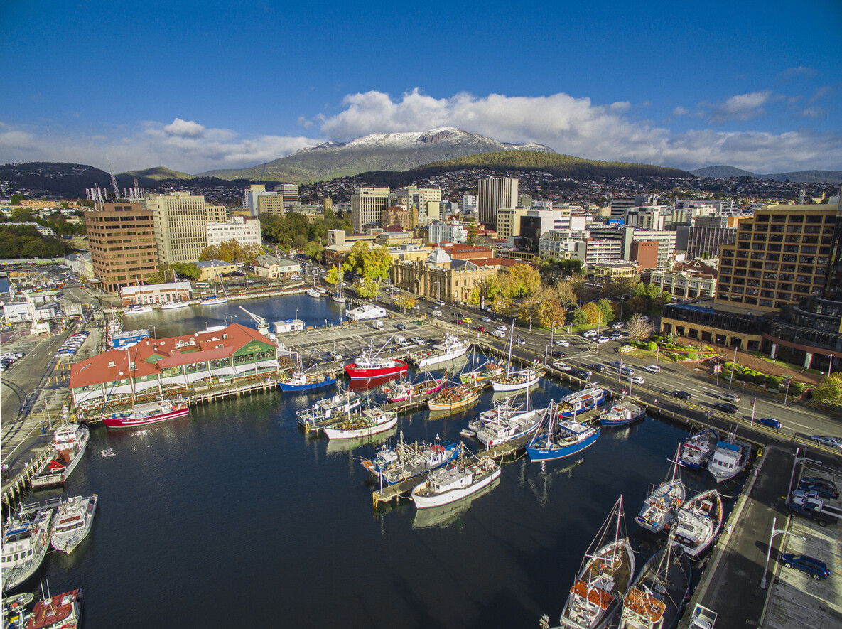 Aerial view of Hobart waterfront in Tasmania, showcasing the vibrant cityscape, harbour, and Mount Wellington in the background, relevant for those aspiring to become a buyer's agent in TAS